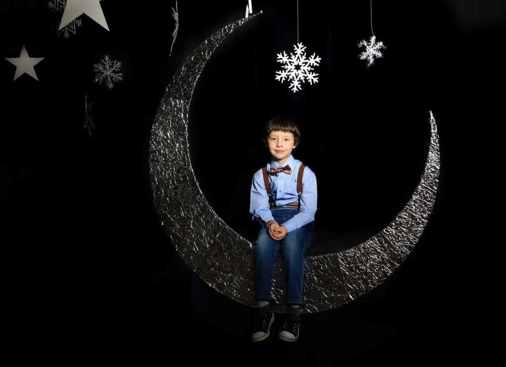 boy sitting on a crescent moon