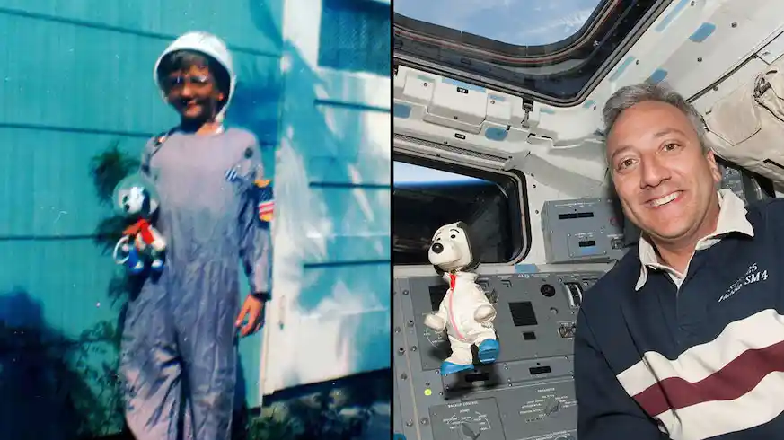 astronaut holding childhood toy in space