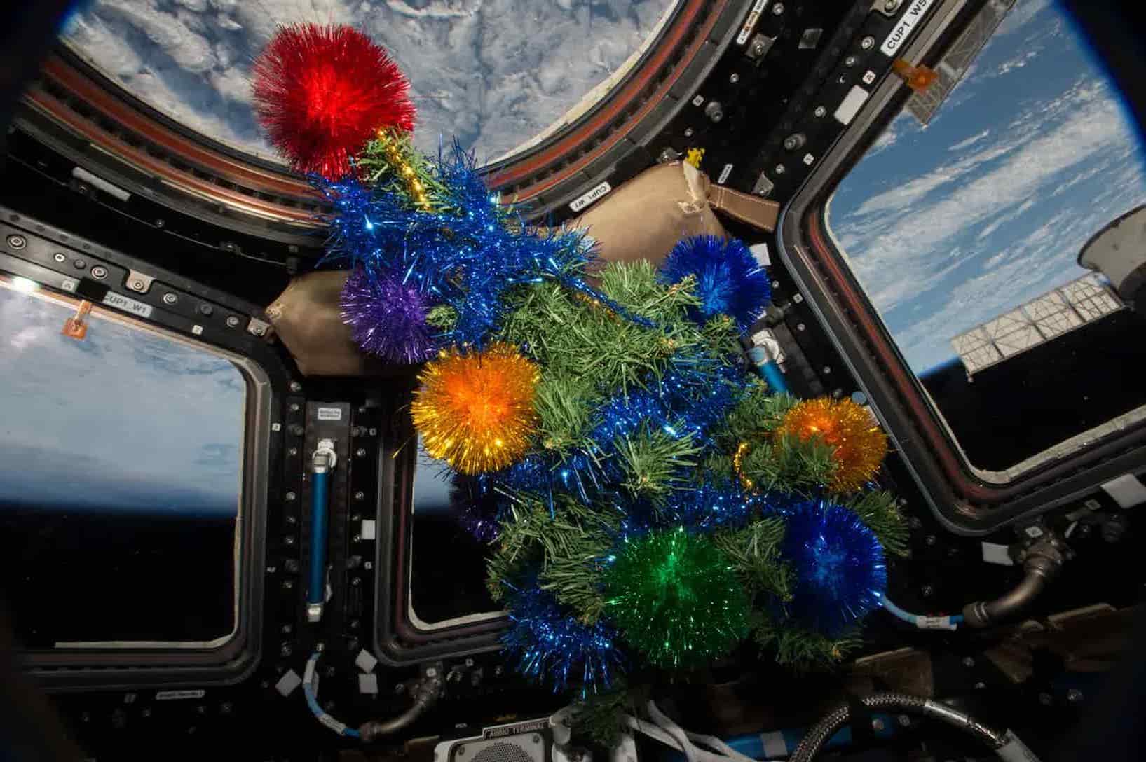 small christmas tree floating inside iss cupola