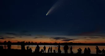 people observing a comet in the night sky